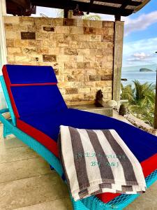 - un lit bleu installé sur une terrasse couverte avec vue sur l'océan dans l'établissement Ocean Suite - Exceptional Beachfront Apartment - Candidasa, à Candidasa