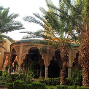 ein Gebäude mit einer Palme davor in der Unterkunft Riad NEJJARINE in Marrakesch