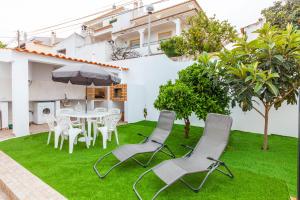 ラゴスにあるCarrob Street Houseのパティオ(芝生の上にテーブルと椅子付)