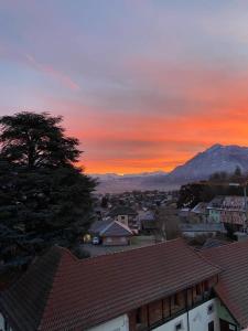 a view of a city with a sunset in the background at Les Afforêts Le Loft in La Roche-sur-Foron