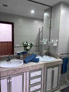 uma casa de banho com 2 lavatórios e um espelho grande em Oasis em Arcos de la Frontera