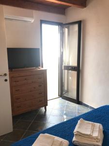 a bedroom with a bed and a dresser with two towels at Appartamenti L'Approdo del Gabbiano in Lampedusa