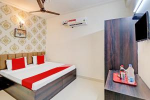 um quarto com uma cama e uma televisão num quarto em OYO Hotel Sky View em Ludhiana