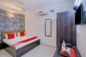 um quarto com uma cama e uma televisão em OYO Hotel Sky View em Ludhiana