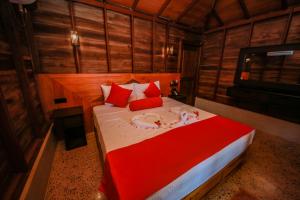 1 dormitorio con 1 cama grande con almohadas rojas en Horizon KiteSurfing Beach Resort, en Kalpitiya