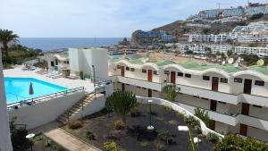 ariaal uitzicht op een gebouw met een zwembad bij Apto. Dulia in Puerto Rico de Gran Canaria
