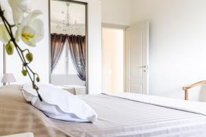 a white bedroom with a bed and a mirror at Sea view apartment between Nice and Monaco - 1 in Villefranche-sur-Mer