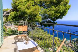 Un balcón con una silla y vistas al océano. en Sea view apartment between Nice and Monaco - 1 en Villefranche-sur-Mer
