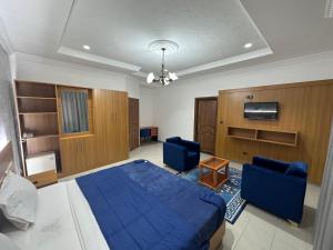 sypialnia z niebieskim łóżkiem i 2 niebieskimi krzesłami w obiekcie Hotel de l'Aeroport w mieście Brazzaville