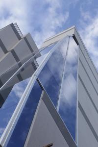 una fachada de cristal de un edificio con el cielo en el fondo en Nubes Apart Hotel en Salta