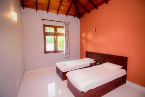 a bedroom with two beds and a window at Airport Villa in Katunayake