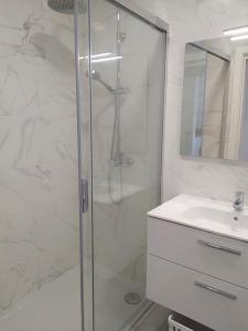 Un baño blanco con ducha y lavabo. en Apartamento Salty Tides, en Altura 23 fotos más