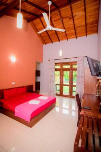 a bedroom with a red bed and a tv in it at Airport Villa in Katunayaka
