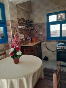 Rural Guest House فندق البيت الريفي في طنطا: مطبخ مع طاولة عليها إناء من الزهور