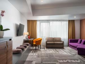 ブカレストにあるMercure Bucharest Uniriiのリビングルーム(ソファ、椅子付)