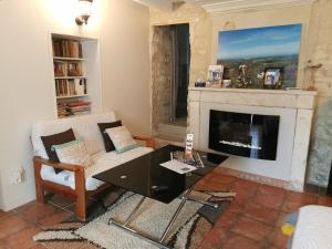 a living room with a couch and a fireplace at Petit havre de tranquillité in Loudun