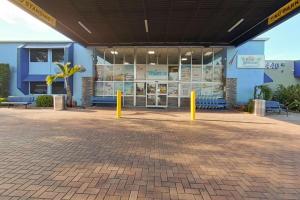 a blue building with yellow poles in front of it at Rodeway Inn & Suites Fort Lauderdale Airport & Cruise Port in Fort Lauderdale