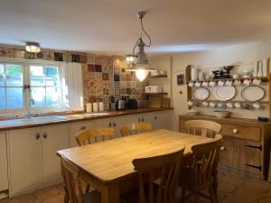 - une cuisine avec une table en bois et des chaises dans l'établissement Picturesque Seaside Cottage Next to Viking Bay - Broadstairs, à Broadstairs