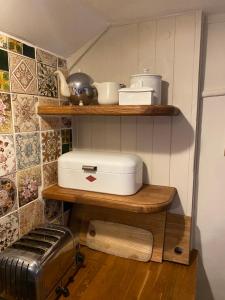 a kitchen with a shelf with a toaster on it at Picturesque Seaside Cottage Next to Viking Bay - Broadstairs in Broadstairs +55 photos