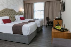 a hotel room with two beds and a desk at Hotel Balmoral Sure Hotel Collection by Best Western in Newcastle upon Tyne