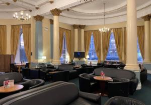 a waiting room with chairs and tables and windows at The Grand Scarborough in Scarborough