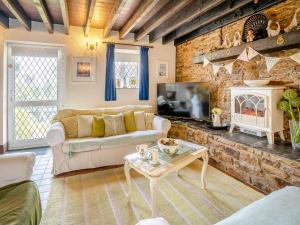 a living room with a couch and a fireplace at Ty Gwyn - Jyy in Gowerton