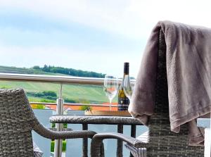 uma mesa com uma garrafa de vinho e dois copos em Villa Bonita del Kaiserstuhl FeWo1 em Sasbach am Kaiserstuhl
