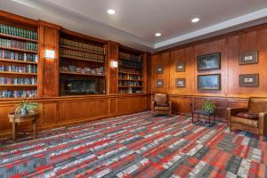 a library with two chairs and bookshelves at MainStay Suites Lexington I-75 in Lexington