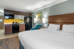 レキシントンにあるMainStay Suites Lexington I-75の大きなベッドとキッチンが備わるホテルルームです。