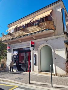 eine Person, die außerhalb eines Gebäudes mit Balkon steht in der Unterkunft Appartement Premium in Beaulieu-sur-Mer