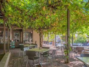 a patio with tables and chairs under a tree at Stay on Lachlan in Cowra