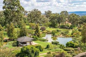 an aerial view of a garden with a house and a lake at Stay on Lachlan in Cowra