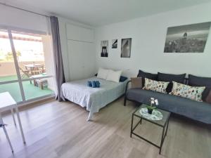 a living room with a couch and a table at "VIVE BENAL BEACH" estudio gran terraza y parque acuático 1319 in Benalmádena +51 photos