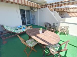 a wooden table and chairs on a balcony at "VIVE BENAL BEACH" estudio gran terraza y parque acuático 1319 in Benalmádena