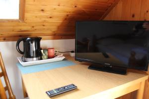 a television sitting on a table with a remote control at Hotel-Restaurant Olympia in Selm