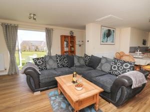 a living room with a couch and a table at Brynteg Cottage in Llanfyrnach