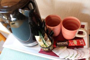 una mensola con due tazze di caffè e una caffettiera di Hotel-Restaurant Olympia a Selm
