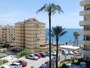 ベナルマデナにあるVIVE BENALMÁDENA Estudio Benal Beach 319 Vistas al Mar, Parque Acuáticoのヤシの木と海の景色を望む駐車場