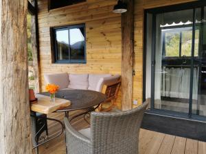 un patio con una mesa y un sofá en una terraza en La Peyregoune, logement en pleine nature et table d'hôtes, en Blieux