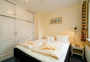 a bedroom with a bed with swans on it at Godewind ebenerdig in Westerland