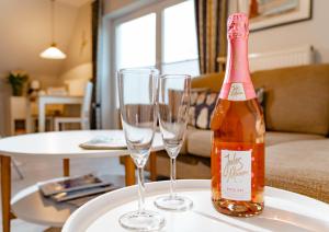 a bottle of wine and two wine glasses on a table at Ferienwohnung Seeute Deern in Westerland +9 photos