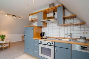 a kitchen with blue cabinets and a sink at Ferienwohnung Seeute Deern in Westerland