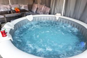 a jacuzzi tub with blue water in it at Villa confortable avec Jacuzzi à Chevannes in Chevannes