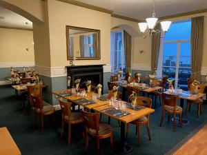 a restaurant with wooden tables and chairs and a fireplace at The Grand Scarborough in Scarborough