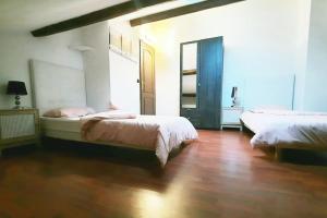 a bedroom with two beds and a wooden floor at Villa confortable avec Jacuzzi à Chevannes in Chevannes