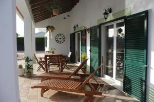 a patio with rocking chairs and a table at Casa Delbon Guest House in Aljezur