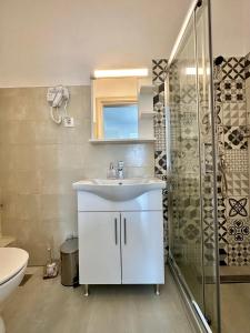 La salle de bains est pourvue d'un lavabo blanc et d'une douche. dans l'établissement Bella House Nikiti, à Nikiti