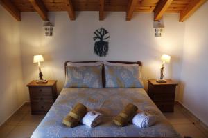 a bedroom with a bed with two night stands and two lamps at Casa Delbon Guest House in Aljezur