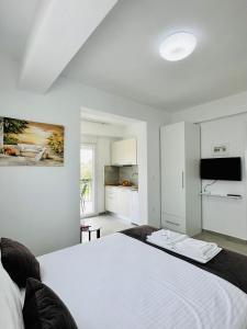 Cet appartement comprend une chambre avec un lit blanc et une cuisine. dans l'établissement Bella House Nikiti, à Nikiti