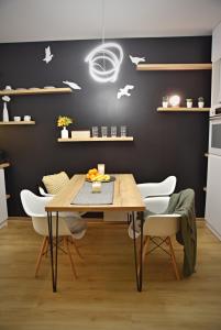 une salle à manger avec une table en bois et des chaises blanches dans l'établissement Apartmán PERGOLA, à Mikulov